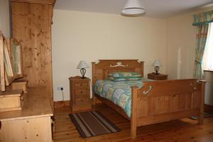a bedroom with a wooden bed and a wooden floor at The Stone Cottage in Kenmare