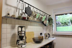 a kitchen with pots and pans hanging from a rack at Ferienwohnungen Schwarzhof -Hanfdell in Nohfelden