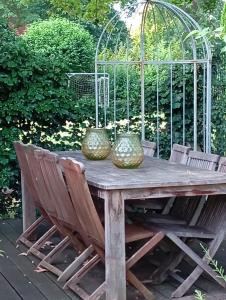a wooden table with chairs and two vases on it at Villa Knoche in Arnsberg