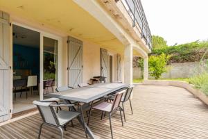 eine Terrasse mit Tisch und Stühlen auf einem Deck in der Unterkunft Agréable logement avec piscine entre mer et vignes in Maureilhan-et-Raméjan
