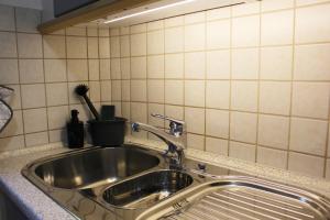 a stainless steel kitchen sink in a tiled kitchen at Ferienwohnungen Schwarzhof -Hanfdell in Nohfelden +34 photos