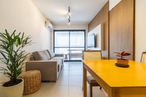 ein Wohnzimmer mit Couch und Tisch in der Unterkunft Refúgio Tropical no San Martin - Destino BSM 203 A in Barra de São Miguel