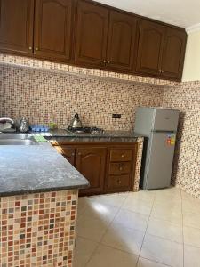 a kitchen with wooden cabinets and a refrigerator at 3 Chaaban 1, 1136 in Larache