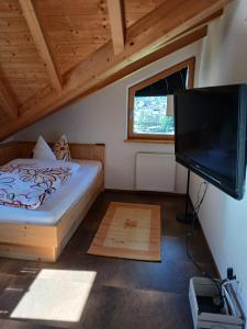 a bedroom with a bed and a flat screen tv at Ferienwohnung Anita in Umhausen