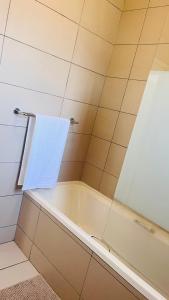 佛维斯Apartment in Fourways的带浴缸和白色毛巾的浴室