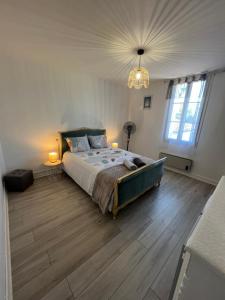 a bedroom with a large bed and a chandelier at Gîte le clos in Saint-Sulpice-de-Faleyrens