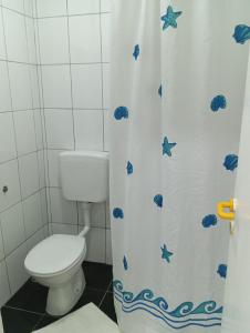 a bathroom with a toilet and a shower curtain at Apartman Mara in Neum