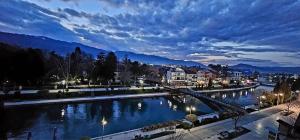 斯特鲁加Struga Riverview Hotel的一座城市的河上过夜的桥梁