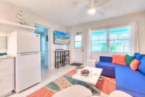 ein Wohnzimmer mit einem blauen Sofa und einem weißen Kühlschrank in der Unterkunft Tropic Terrace #21 - Beachfront Rental in St Pete Beach