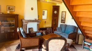 Una sala de estar con un sofá azul y una silla. en Maison Rumoal, en Saint Hernin