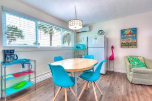 a room with a table and chairs and a refrigerator at Tropic Terrace Suite #29 - Beachfront Resort in St Pete Beach