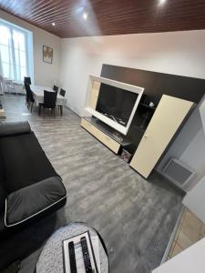 a living room with a flat screen tv and a couch at Gîte le clos in Saint-Sulpice-de-Faleyrens
