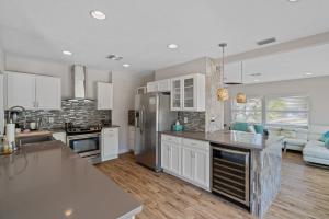 a large kitchen with white cabinets and a kitchen island at A Sunset Dream - Monthly Beach Rental in Clearwater Beach