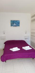 a purple bed with two white towels on it at Soldeu Paradis Tarter Baix in El Tarter