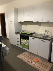 a kitchen with white cabinets and a sink at Appartamento fronte spiaggia climatizzato in Ardore Marina +10 photos