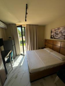 ZverneciVilla Shehu的一间卧室，配有一张床、一张书桌和一扇窗户 更多11张照片