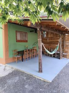 Casa con hamaca, mesa y sillas en Manganiari Springs Cabin Retreat, en Dhipótama