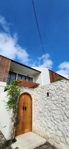 Casa con puerta de madera y pared de piedra en Swaha at Canggu Villa 1, en Canggu