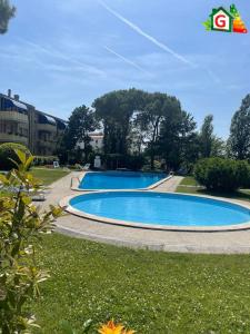 two swimming pools in a park with a kite in the sky at Apartment with Pool in Cavalino Jesolo in Cavallino-Treporti