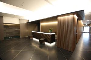 a lobby with a desk and benches in a building at Urban Hotel Kyoto Nijo Premium in Kyoto