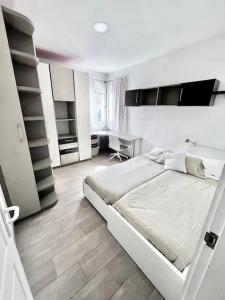 a white bedroom with a bed and a desk at Apartamento en Ciudad Jardín in Las Palmas de Gran Canaria