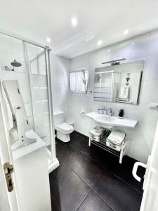 a white bathroom with a sink and a toilet at Apartamento en Ciudad Jardín in Las Palmas de Gran Canaria