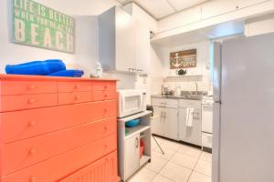 a kitchen with a red dresser and a microwave at Tropic Terrace Suite #24 - Beachfront Resort in St Pete Beach