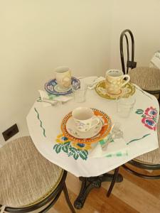 a table with two cups and plates on it at Sa Pruninca in Villanova Monteleone +18 photos