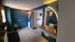 une salle de bain avec des murs bleus et un lavabo et un miroir dans l'établissement La Maison du Bord du Lac, à La Chevrolière 52 autres photos