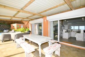 a patio with a table and benches and a kitchen at Zi Limon in Rodrigues Island