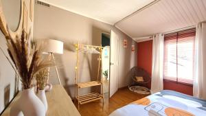 - une chambre avec un lit et une table avec un vase dans l'établissement La Maison du Bord du Lac, à La Chevrolière