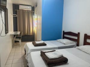 马卡帕Xenius Hotel - Apt Particular的一间设有两张床和蓝色墙壁的客房 更多12张照片
