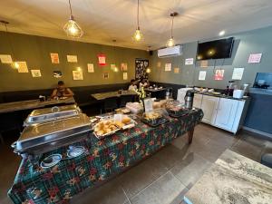 马卡帕Xenius Hotel - Apt Particular的餐厅的自助餐,包括餐桌上的食品