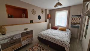 une petite chambre avec un lit et une commode dans l'établissement La Maison du Bord du Lac, à La Chevrolière