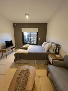 a bedroom with a large bed and a couch at Champa Apart Pilar - EXCELENTE UBICACIÓN EN PILAR in Pilar