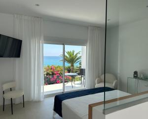 a bedroom with a bed and a view of the ocean at Tierratlanta Suites in Zahara de los Atunes