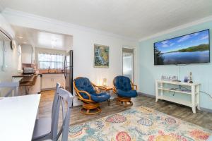 a living room with two blue chairs and a kitchen at Tropic Terrace Suite #44 - Beachfront Resort in St Pete Beach