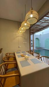a dining room with a table with chairs and lights at Bohemian Private pool Villa - Fulton Casablanca in Beran-kidul