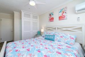 a bedroom with a large bed with pink flowers at Tropic Terrace Suite #44 - Beachfront Resort in St Pete Beach