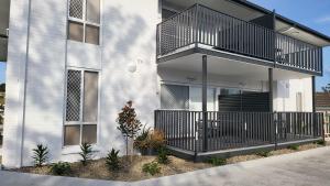 a building with a balcony on the side of it at Husky 19 Beautifully Appointed Apartments - GREAT LOCATION - in the heart of Husky in Huskisson
