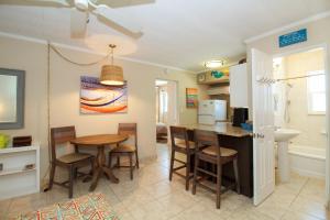 una cucina e una sala da pranzo con tavolo e sedie di Tropic Terrace Suite #45 - Beachfront Resort a St Pete Beach