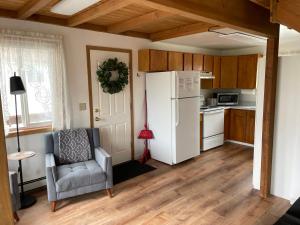 Il comprend une cuisine équipée d'un réfrigérateur blanc et d'une chaise. dans l'établissement Peaceful Acres Cabin 3 - Soldotna, AK, à Kasilof 36 autres photos