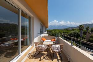 a balcony with chairs and a table with a view at maria stella in Calvi