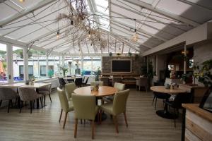 a restaurant with tables and chairs and a tv at Hive Townhouse in Aberaeron