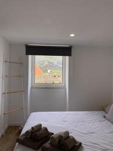 a bedroom with a bed with towels on it at Lugar da Borralheira in Verdelhos