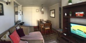 ein Wohnzimmer mit einem Sofa und einem TV in der Unterkunft Departamento Jardin Urbano 3D y 2B-Valdivia in Valdivia