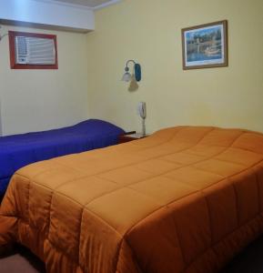 a bedroom with two beds and a phone on the wall at HSJ Balcarce in Balcarce