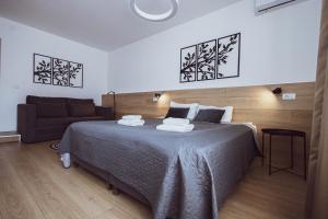 a bedroom with a large bed and a couch at BG Exclusive Suites in Belgrade