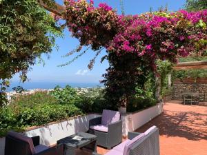 a patio with a table and chairs and flowers at Casa Blu in Anacapri