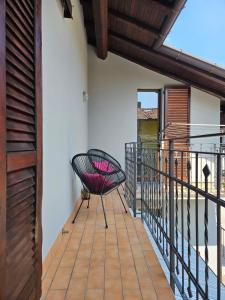 a balcony with a black chair on a building at Sveva Haven Malpensa in Case Nuove
